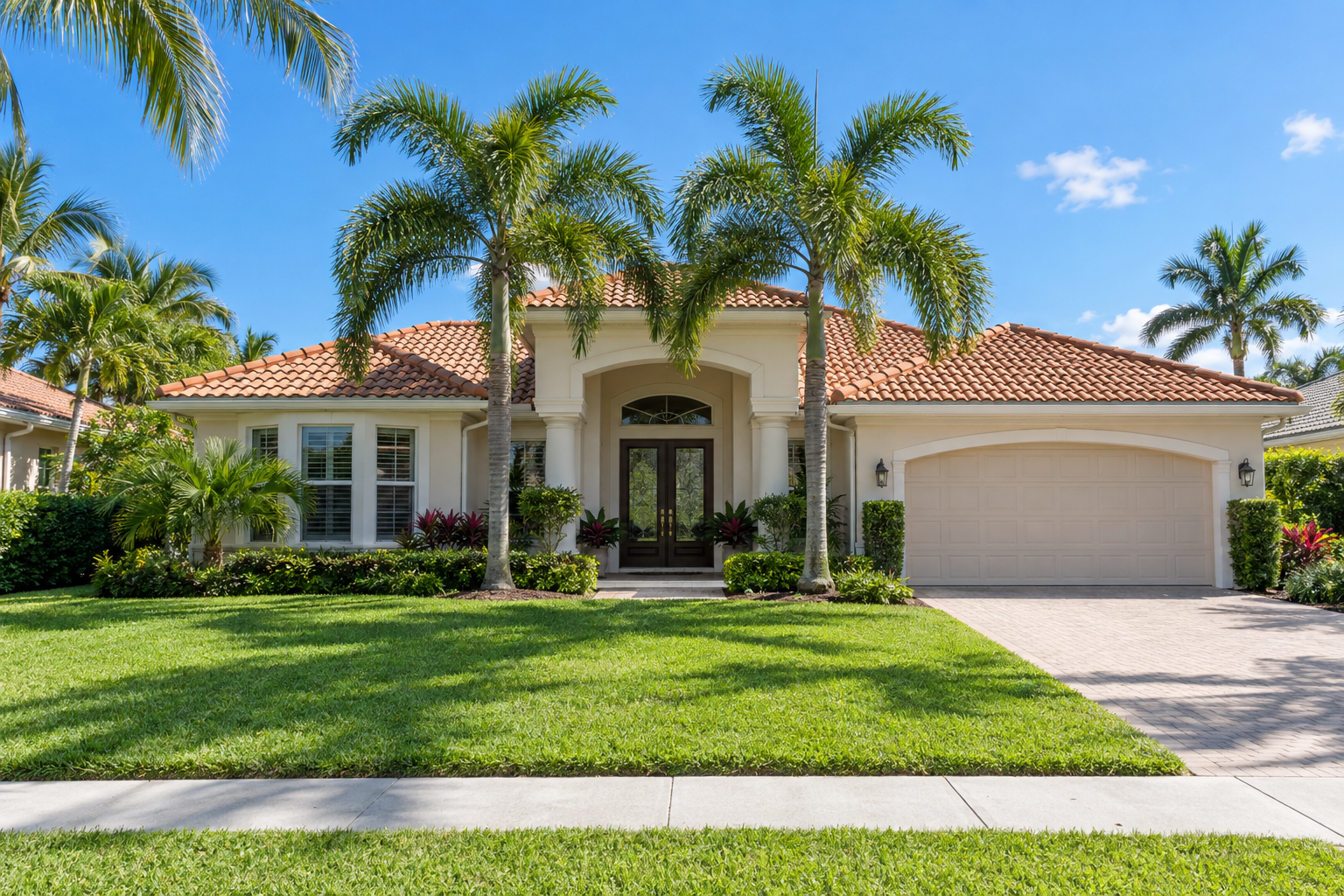 Florida suburban home exterior with manicured lawn, palm trees and a for-sale sign in bright sunshine