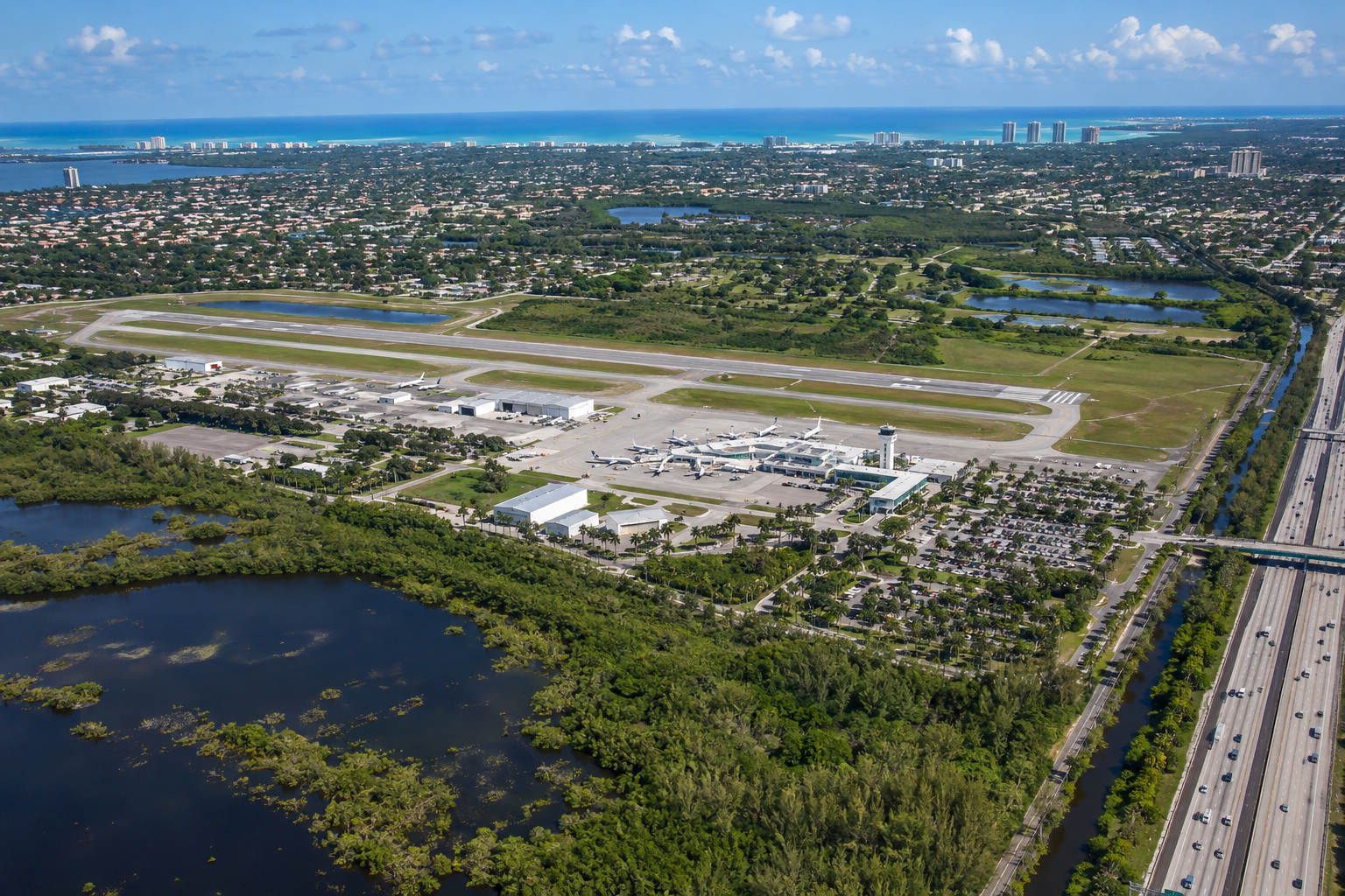 Aerial view of Palm Beach International Airport runways and terminal amid South Florida suburban landscape